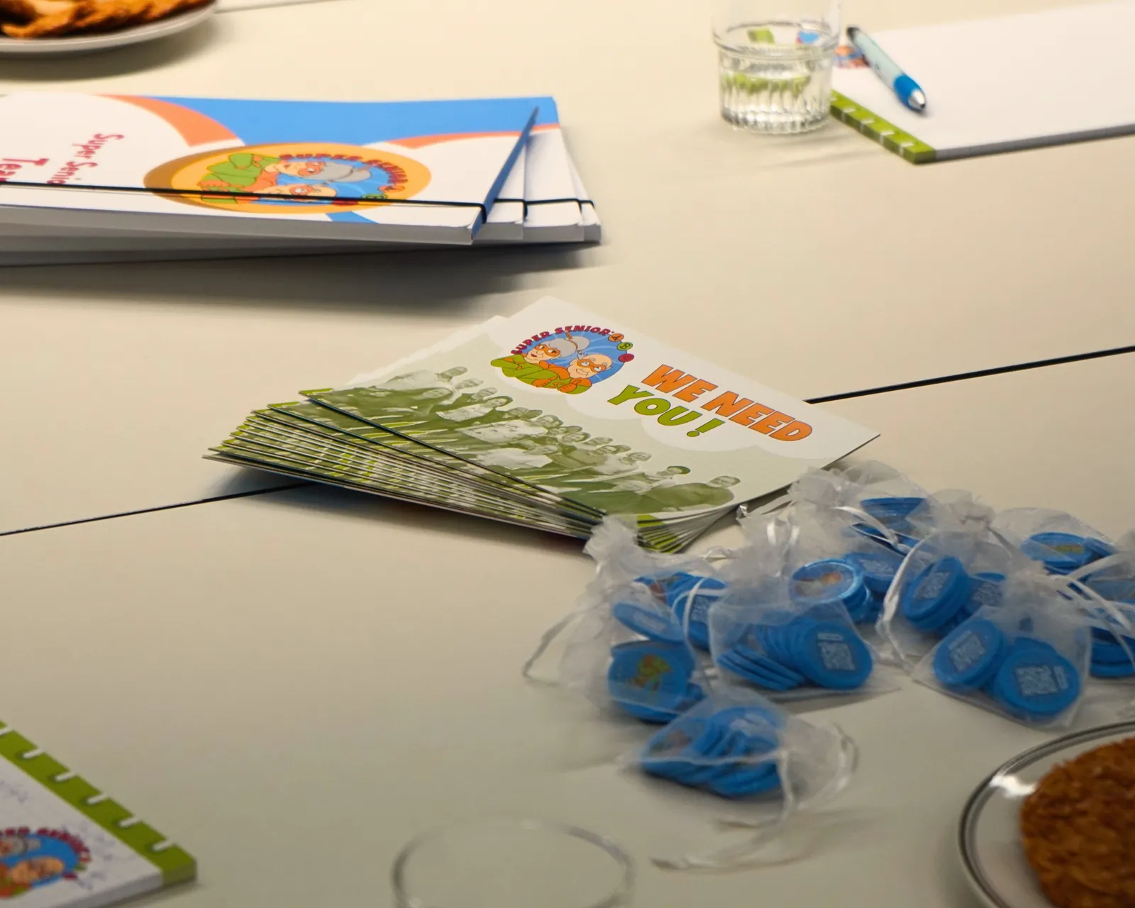 Flyers et goodies Super Senior posés sur la table lors de la visite du Ministre Max Hahn au service Super Senior du MEC asbl