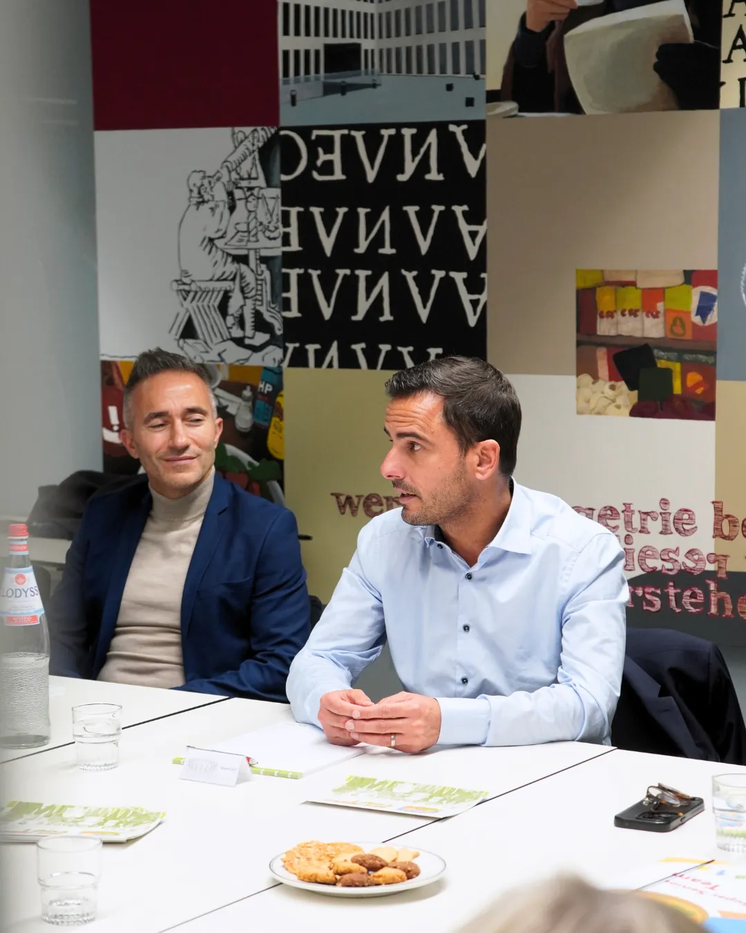 Deux invités assis à la table de réunion lors de la visite du Ministre Max Hahn au service Super Senior du MEC asbl